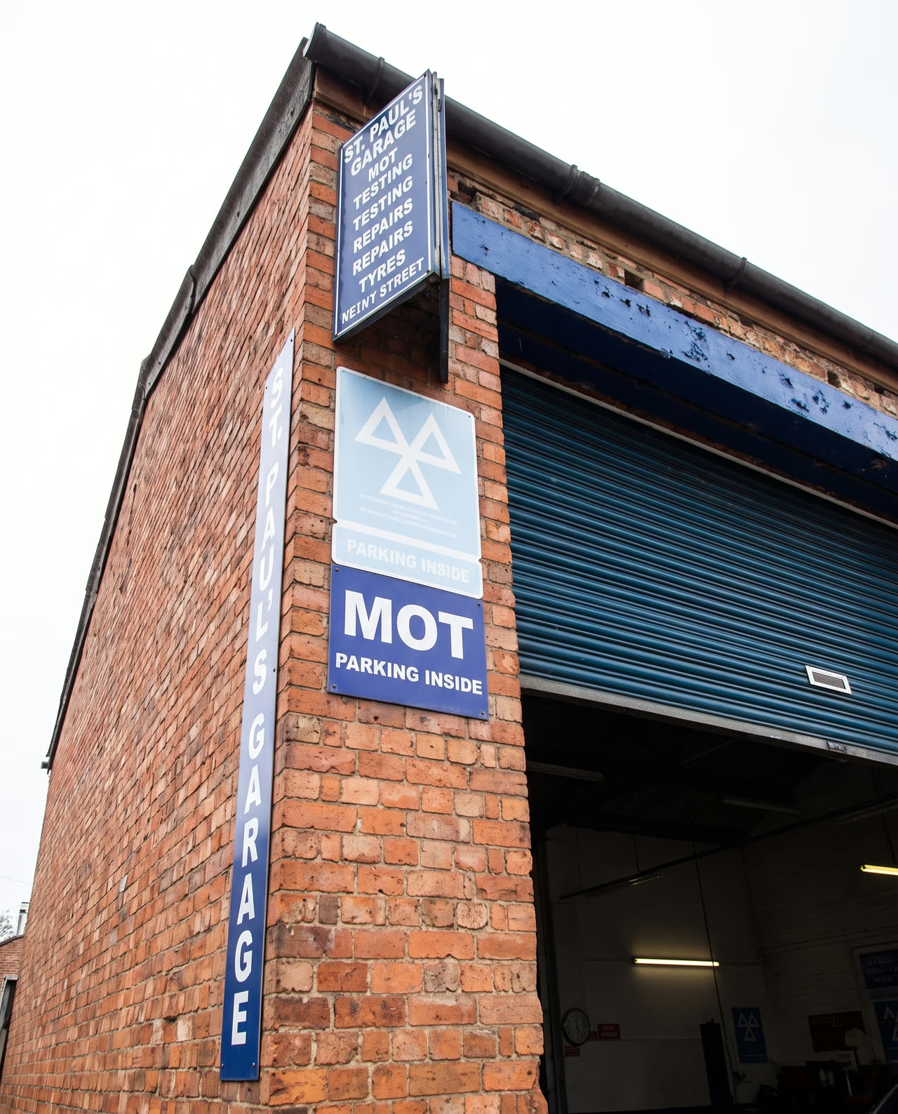 The blue St Paul's Garage services sign on the brick pier